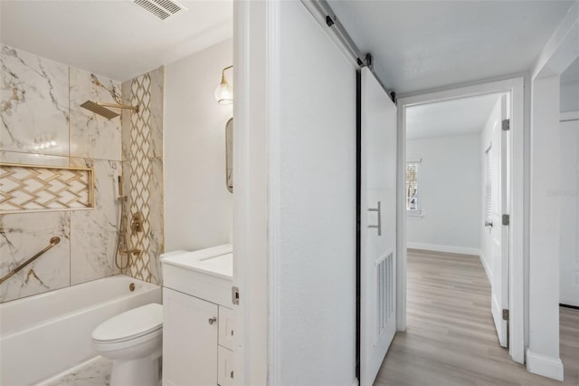 full bathroom with vanity, tiled shower / bath combo, wood-type flooring, and toilet