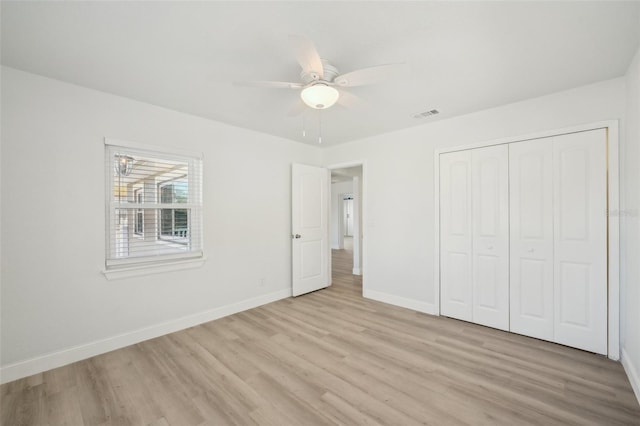 unfurnished bedroom featuring light hardwood / wood-style flooring, ceiling fan, and a closet