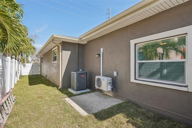 view of property exterior featuring a yard, central AC unit, and ac unit