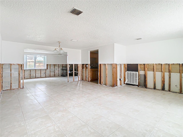 unfurnished room featuring light tile patterned floors, visible vents, and a textured ceiling