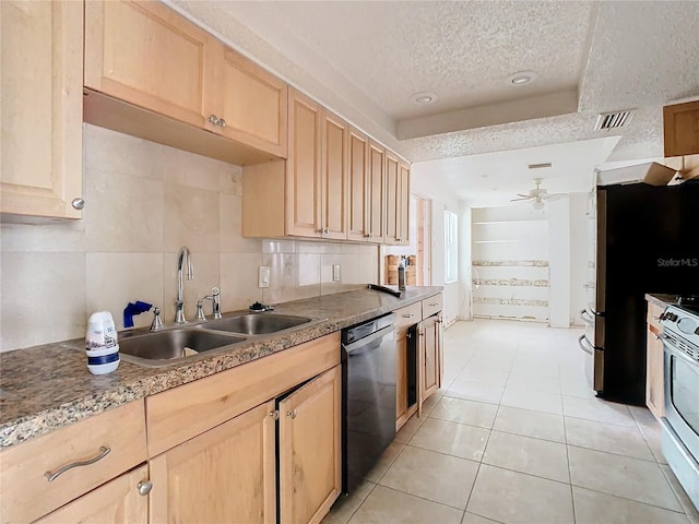 kitchen featuring black dishwasher, visible vents, a sink, and light brown cabinetry