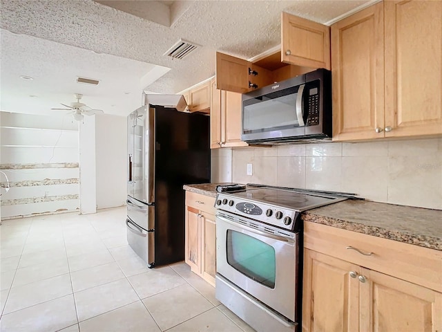 kitchen with stainless steel appliances, visible vents, and light brown cabinets