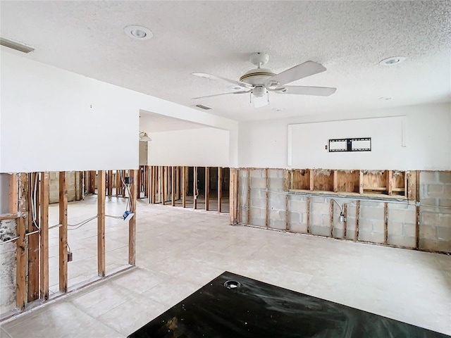 unfurnished room featuring ceiling fan and a textured ceiling