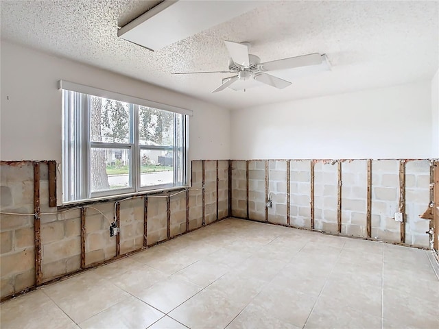 empty room with a textured ceiling and ceiling fan