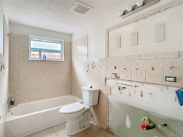 bathroom featuring tile walls, visible vents, toilet, a textured ceiling, and tile patterned flooring