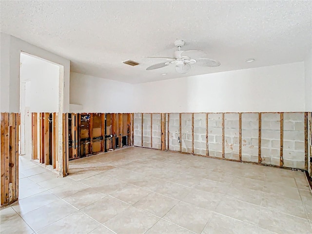 spare room featuring ceiling fan, a textured ceiling, and visible vents