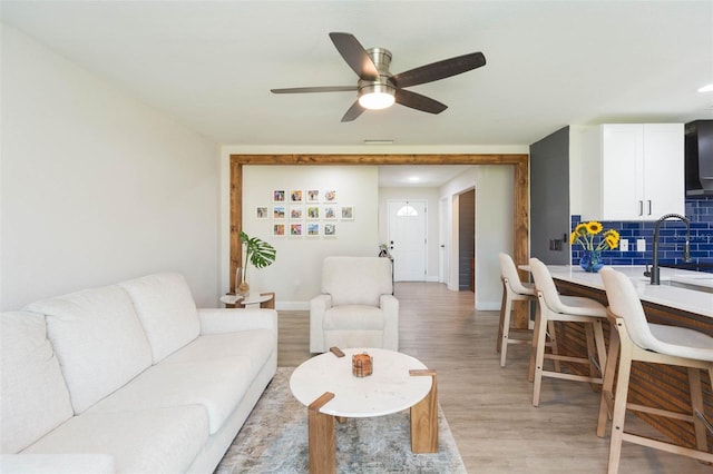 living room featuring light hardwood / wood-style flooring and ceiling fan