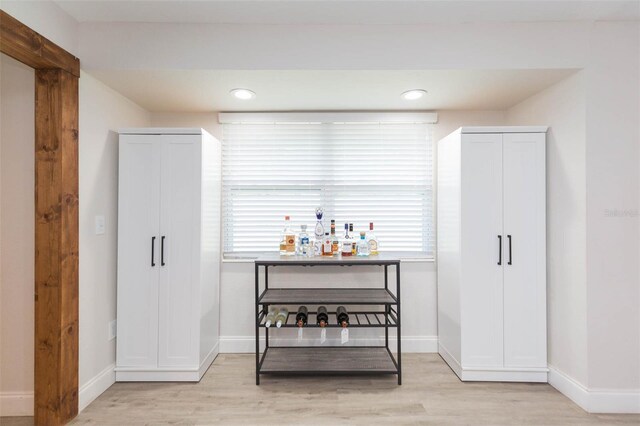 bar with light hardwood / wood-style floors