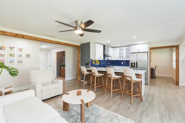 living room with sink, ceiling fan, and light hardwood / wood-style flooring