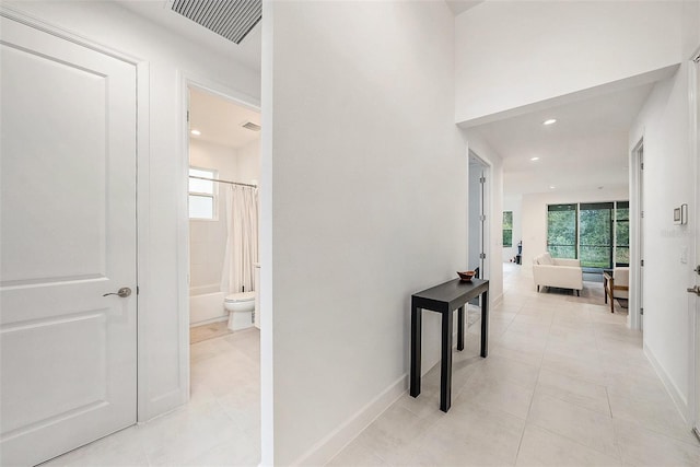 corridor with light tile patterned floors and plenty of natural light