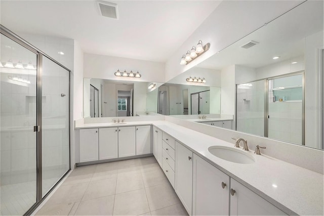 bathroom featuring tile patterned floors, a shower with shower door, and vanity