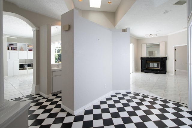 hallway featuring ornamental molding and a textured ceiling