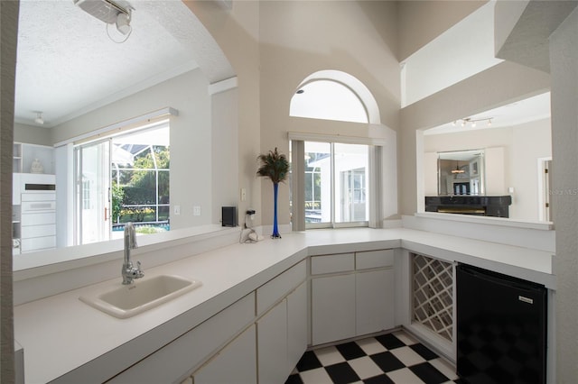 bathroom featuring crown molding, plenty of natural light, a textured ceiling, and vanity