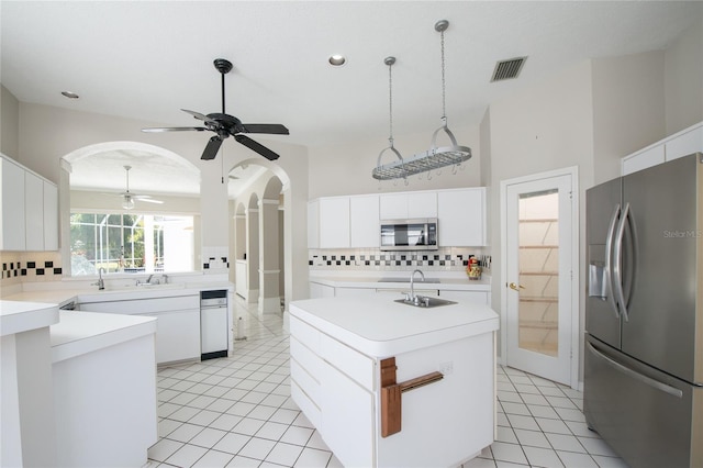 kitchen with white cabinetry, appliances with stainless steel finishes, and a kitchen island with sink