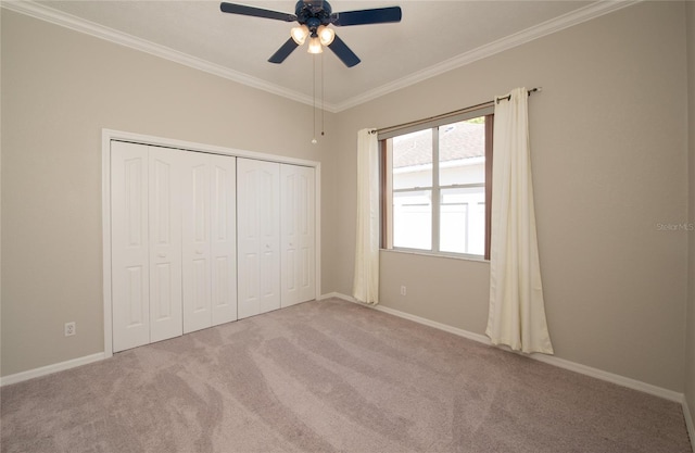 unfurnished bedroom featuring ceiling fan, light colored carpet, ornamental molding, and a closet