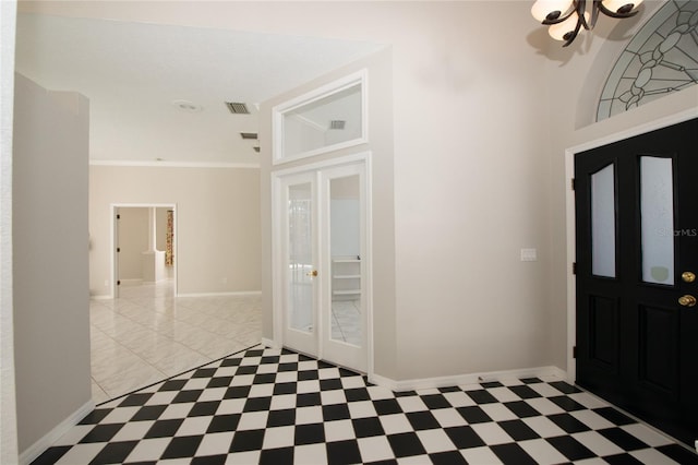 entryway with crown molding and french doors