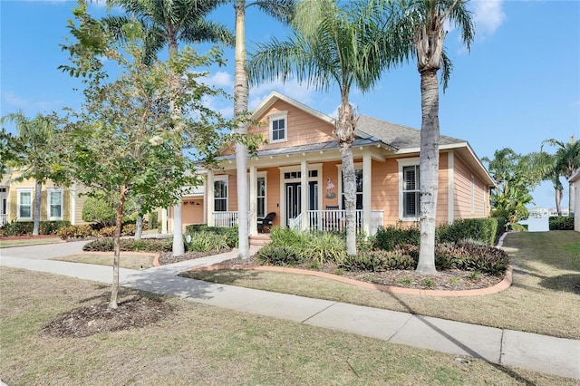 view of front of property with a garage, a front lawn, and covered porch