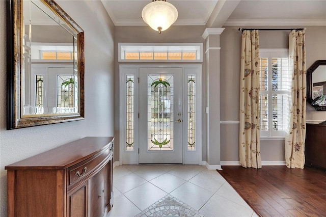 entrance foyer with ornamental molding and light hardwood / wood-style floors