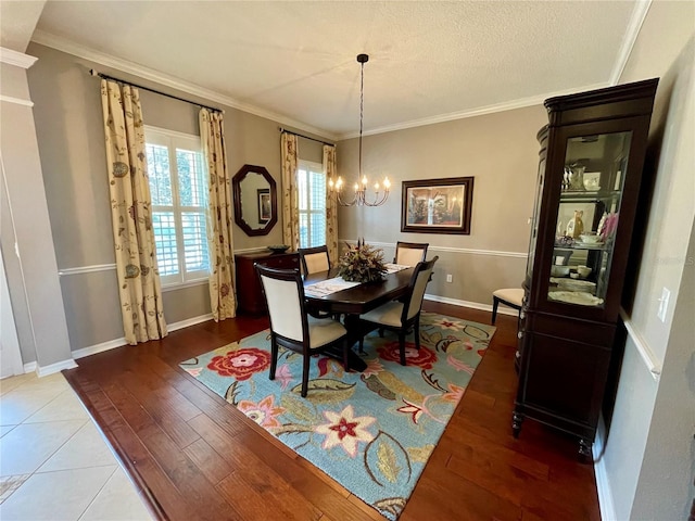 dining space with ornamental molding, wood-type flooring, and a notable chandelier