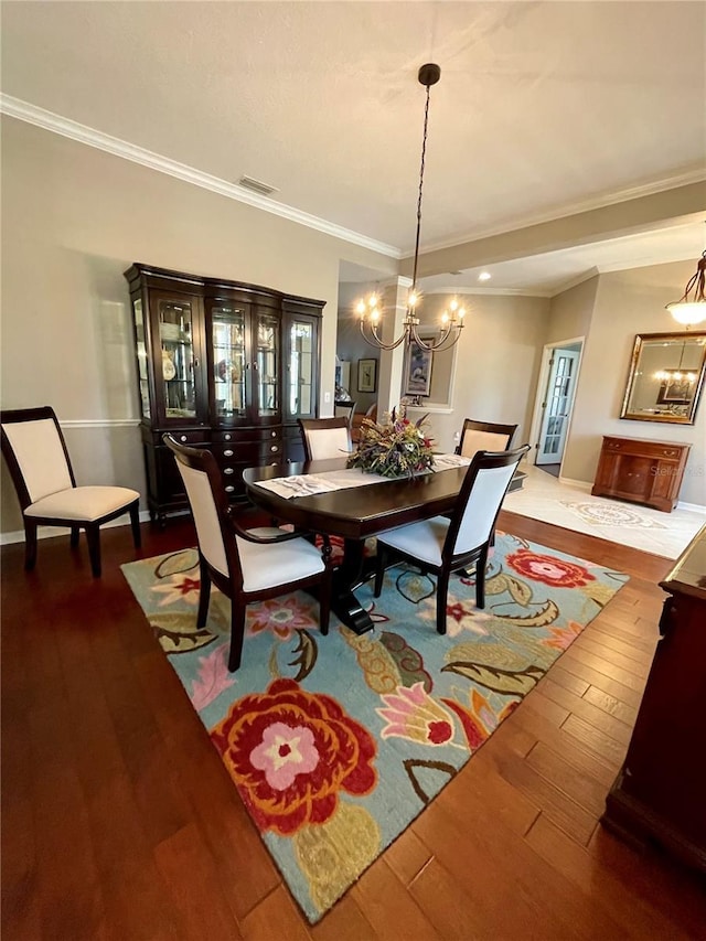 dining room featuring hardwood / wood-style flooring, crown molding, and a notable chandelier