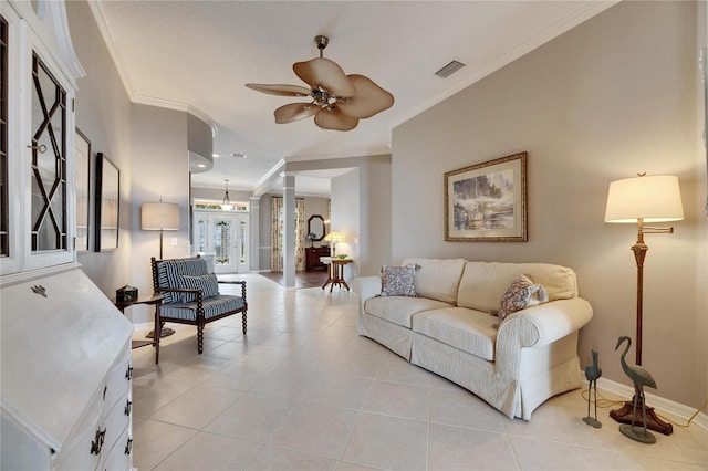 tiled living room featuring crown molding, ceiling fan, and ornate columns