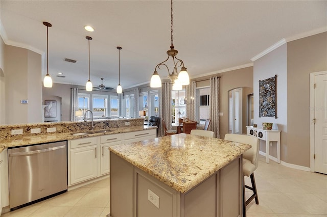 kitchen with pendant lighting, sink, a breakfast bar, light stone counters, and stainless steel dishwasher