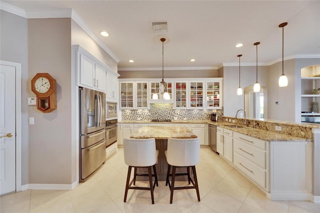 kitchen featuring stainless steel appliances, white cabinetry, a kitchen breakfast bar, and kitchen peninsula