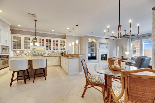 kitchen featuring appliances with stainless steel finishes, decorative light fixtures, sink, and a breakfast bar area