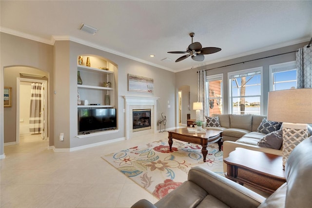 tiled living room with ornamental molding, built in features, and ceiling fan