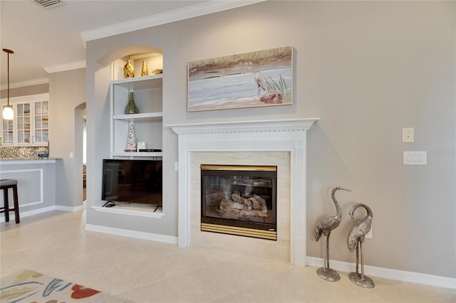 living room with tile patterned flooring, ornamental molding, and built in shelves