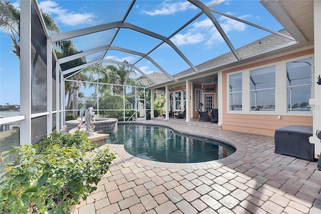 view of pool featuring an in ground hot tub, ceiling fan, a patio area, and glass enclosure