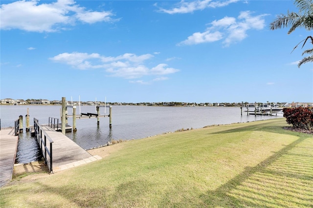 view of dock with a yard and a water view