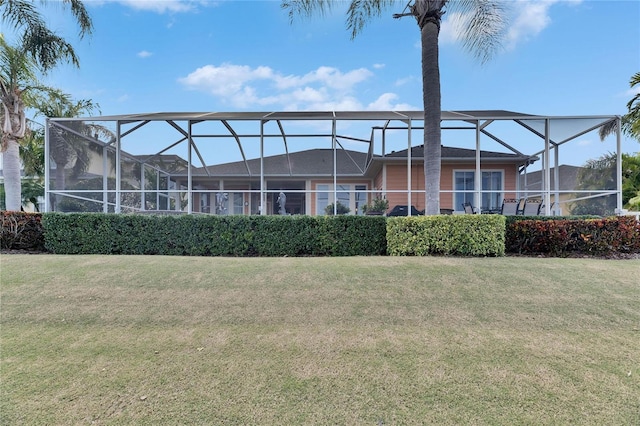 rear view of property with a yard and a lanai