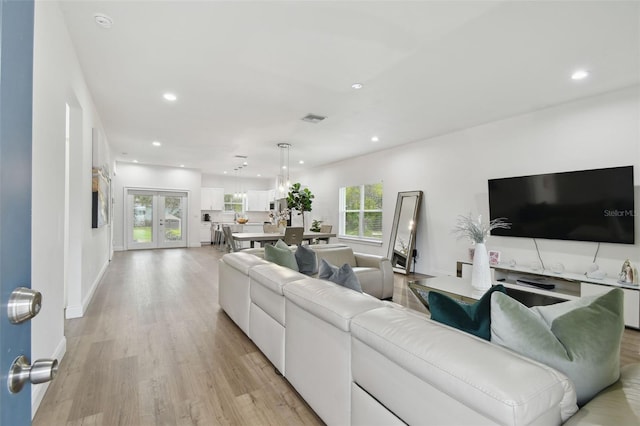 living room with french doors and light hardwood / wood-style flooring