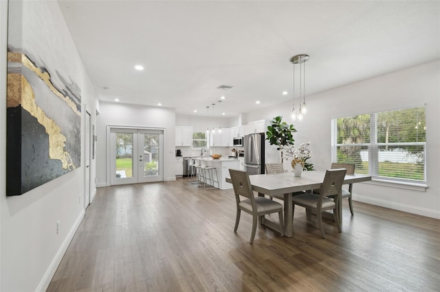 dining space featuring dark hardwood / wood-style flooring, sink, and french doors