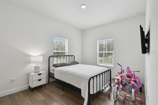 bedroom with dark hardwood / wood-style floors