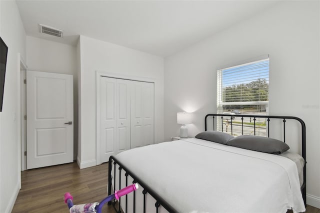 bedroom with dark hardwood / wood-style floors and a closet