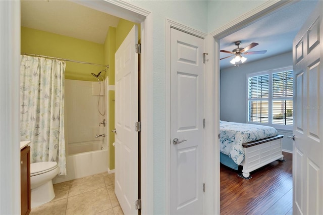 bedroom with connected bathroom, light tile patterned floors, and ceiling fan