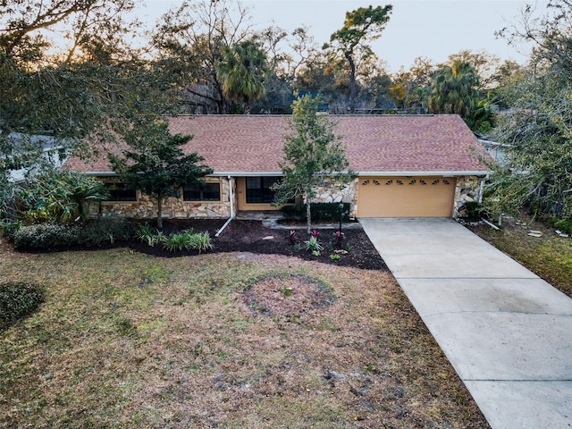 ranch-style home with a garage and a front yard