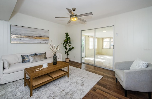 living room with ceiling fan and dark hardwood / wood-style flooring