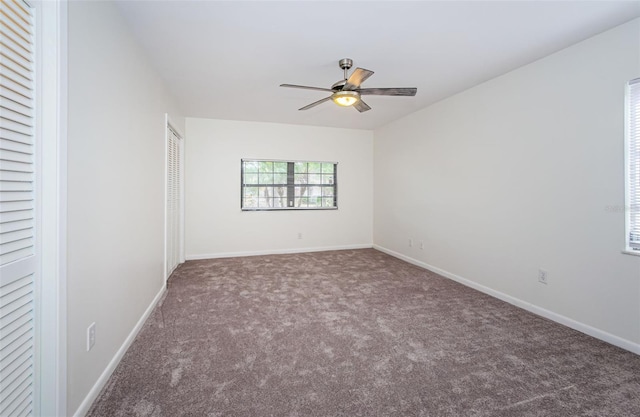 carpeted spare room featuring ceiling fan