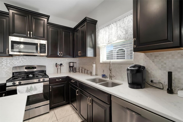 kitchen featuring stainless steel appliances, sink, decorative backsplash, and light tile patterned floors