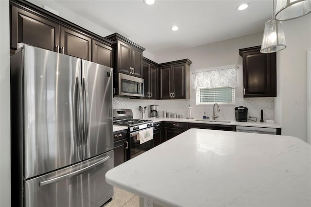 kitchen with sink, backsplash, stainless steel appliances, and hanging light fixtures