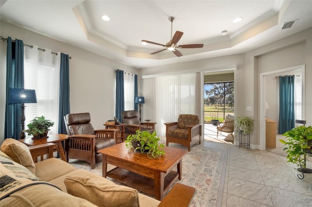 living room with crown molding, a wealth of natural light, ceiling fan, and a tray ceiling