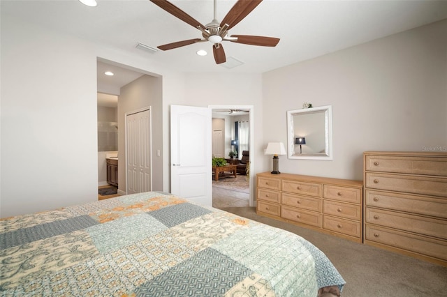 carpeted bedroom featuring ensuite bathroom, ceiling fan, and a closet