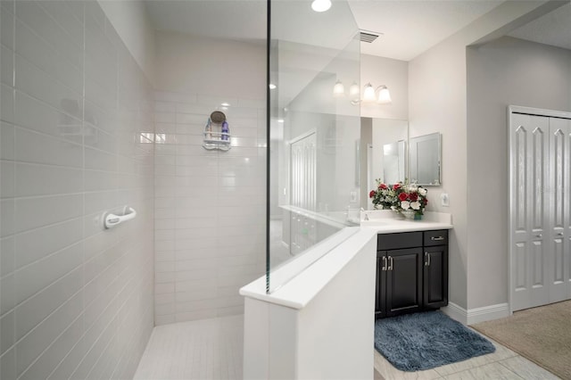 bathroom featuring vanity, tiled shower, and tile patterned floors