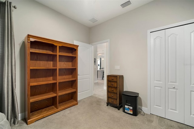 bedroom with light carpet and a closet