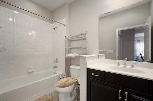 full bathroom featuring tiled shower / bath, vanity, and toilet