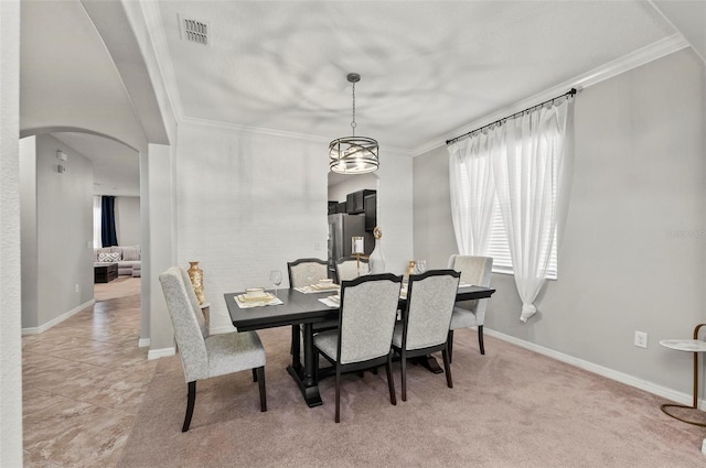 dining room featuring ornamental molding, arched walkways, visible vents, and baseboards