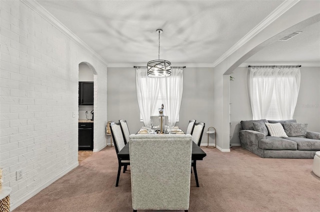 dining area featuring visible vents, arched walkways, a wealth of natural light, and light colored carpet